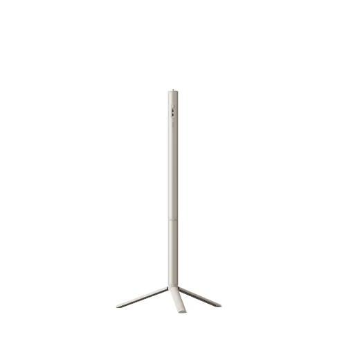 A minimalist, slim floor lamp with a vertical cylindrical column and a tripod-style base, finished in a warm off-white or cream color, shown against a solid white background.