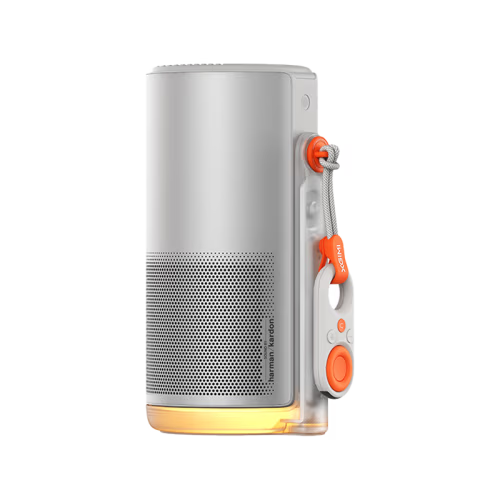 A silver cylindrical portable projector with a clear side strap holding an orange and white remote, shown on a plain white background.